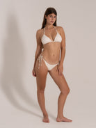 Front view of white triangle bikini with halter top and tie-side bottom