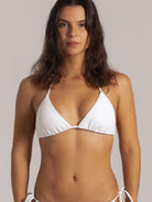 Close-up of woman wearing a white triangle bikini top with thin straps