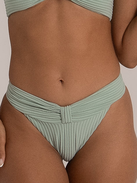 Close-up of twist band detail on mint green bikini bottom in ribbed fabric.