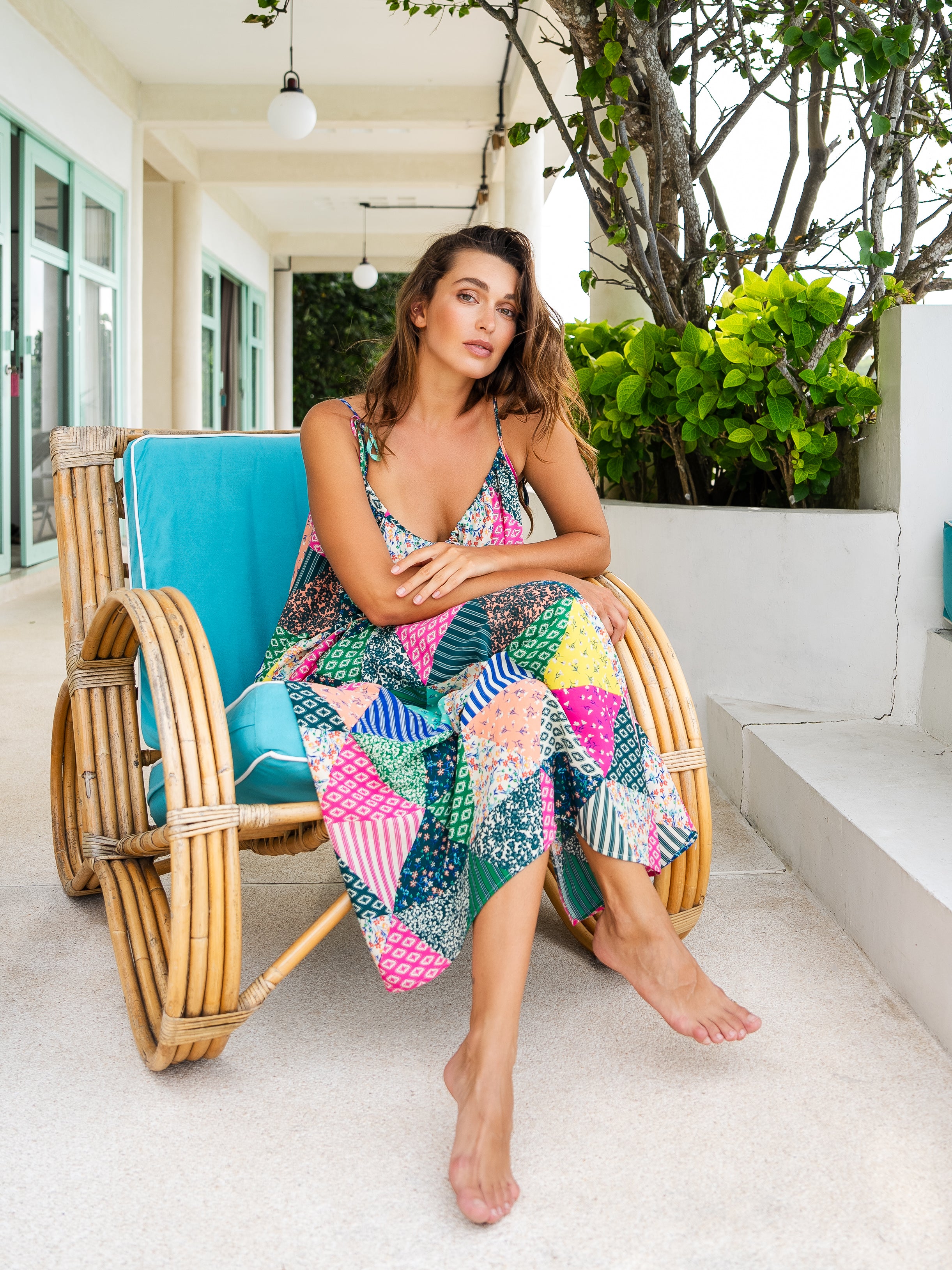 Woman in a geometric print resort maxi dress sitting on a beach chair