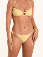 Women’s yellow bikini bottom featuring a side ring and adjustable ties.