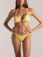 Zoomed-in detail of tie-side yellow bikini bottom for beachwear