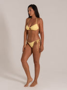 Halter neck yellow bikini with cut-out ring front and cheeky fit, side pose