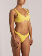 Side view of yellow high leg bikini set with textured fabric and scoop neckline