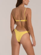 Back angle view of yellow high cut bikini bottom with textured fabric and scoop fit