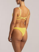 Angled back view of yellow ribbed bikini bottom with cheeky coverage
