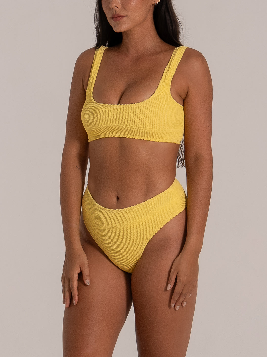Front-side view of high-rise bikini bottom in mustard yellow with sculpting fit