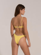 Model wearing yellow textured bikini set with underwire top and V-cut bottom