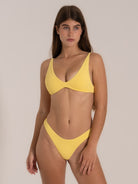 Front angle of yellow textured bikini top offering light support and flattering shape