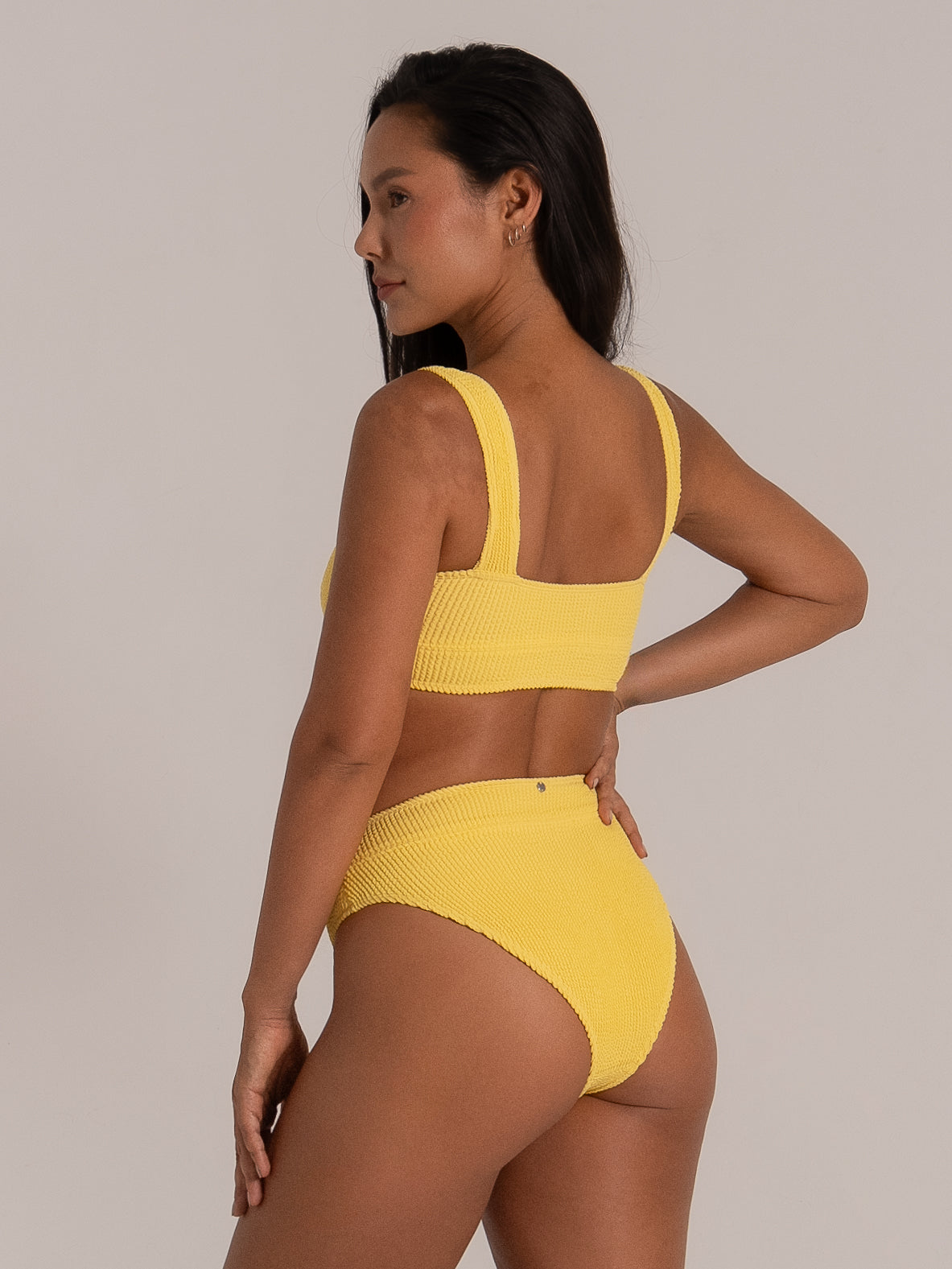 Back view of yellow textured bikini top with wide shoulder straps