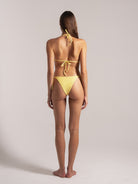 Model showing back of yellow triangle bikini with cheeky cut and textured fabric
