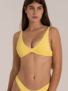 Minimalist yellow triangle-style bikini top with deep neckline and seamless fit